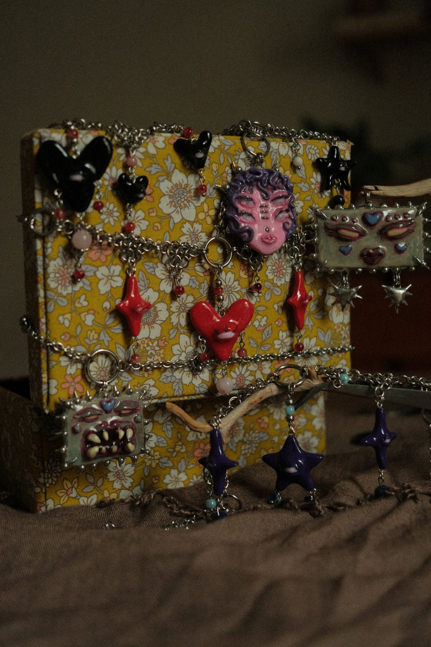 odd fairycore creatures necklaces wrapped around yeallow floral chest