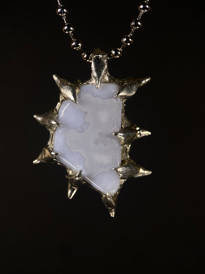 Close-up of handmade spiky Blue Chalcedony pendant with sterling silver setting, calming crystal, artisan jewelry design